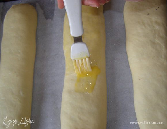 Выложить рулеты на смазанный маслом противень, верх смазать желтком. Дать постоять 30 минут.