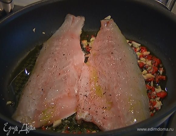 Выложить оба куска филе в сковороду с чесноком и перцем кожей вниз и обжарить с двух сторон практически до готовности, затем добавить вино.