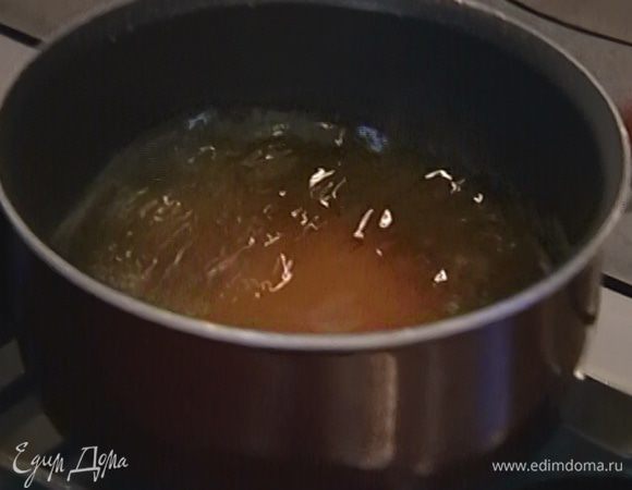 Приготовить карамель: оставшийся сахар всыпать в небольшую кастрюлю, залить 50 мл воды и на медленном огне сварить сироп, затем влить его в сковороду с кунжутом и, перемешивая, прогревать до золотистого цвета.
