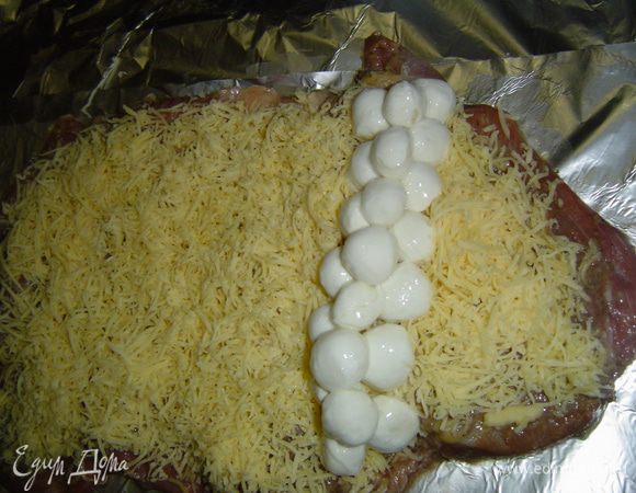 Отступив пару сантиметров от края, выкладываем моцареллу и туго сворачиваем мясо в рулет,