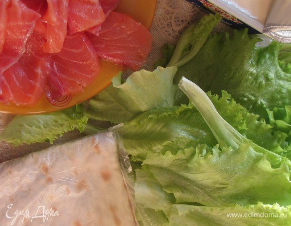 Листья салата вымыть и высушить. Рыбу нарезать тонкими пластиками.