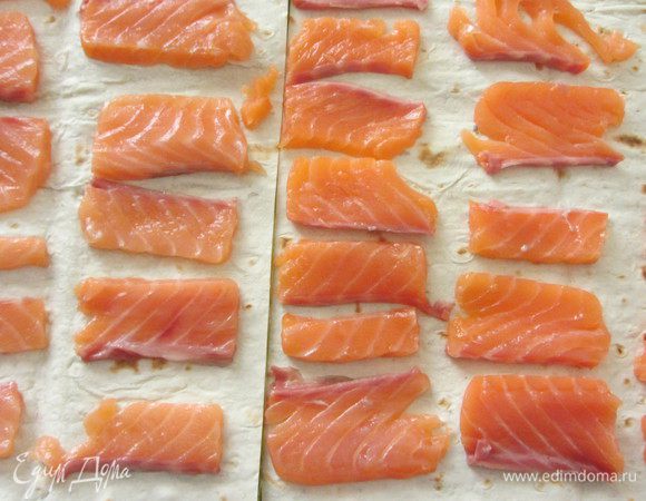 Салат накрыть второй половинкой лаваша и выложить на него рыбу.
