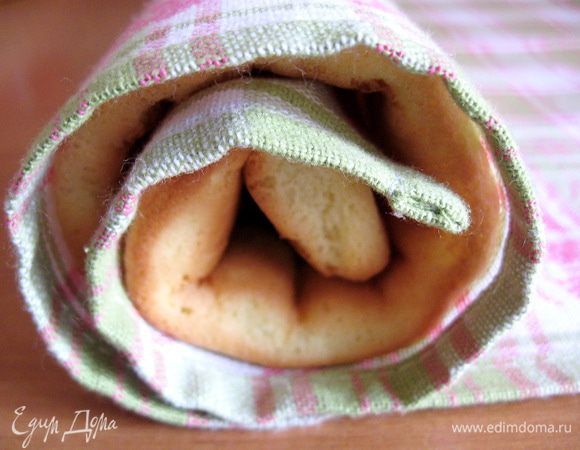 Готовый бисквит переворачиваем на полотенце, снимаем пергамент и сворачиваем бисквит с полотенцем в рулет и оставляем до полного остывания.