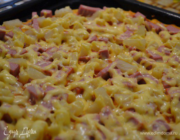 Готовую пиццу нарезать треугольниками и сразу же  подавать.