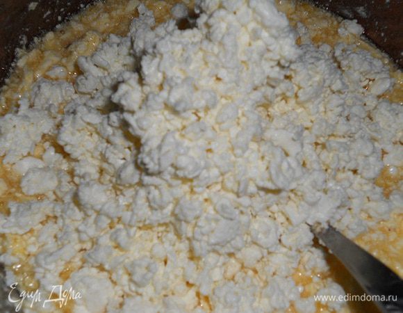 Добавить половину творога, перемешать.