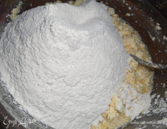 Добавить муку и перемешать, затем кладем на доску припыленую мукой и замешиваем мягкое тесто.