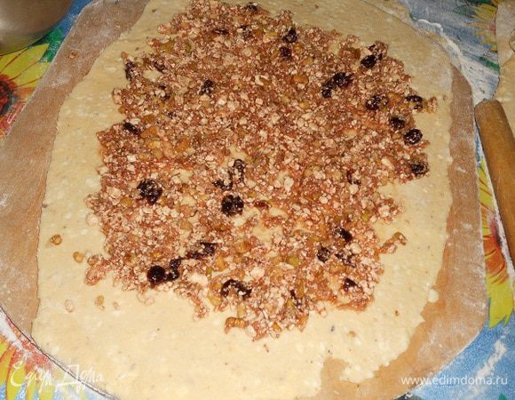 Достать тесто из холодильника, разделить надвое, раскатать, нанести начинку не большим слоем...