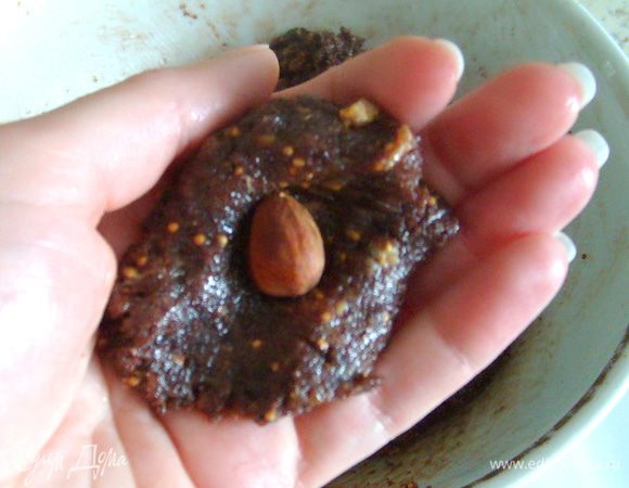 Поставить на 15-20 мин. смесь в холодильник. Сформировать из слегка охлажденной смеси шарики, внутрь каждого из них положить миндаль. Обвалять конфеты в бисквитных крошках, к которым можно добавить измельченный миндаль. Поставить готовые конфеты в холодильник для охлаждения.