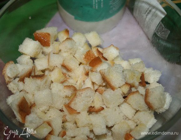 Ломтики хлеба нарезать кубиками, положить их в миску и полить растопленным сливочным маслом (50 г). Отставить в сторонку.