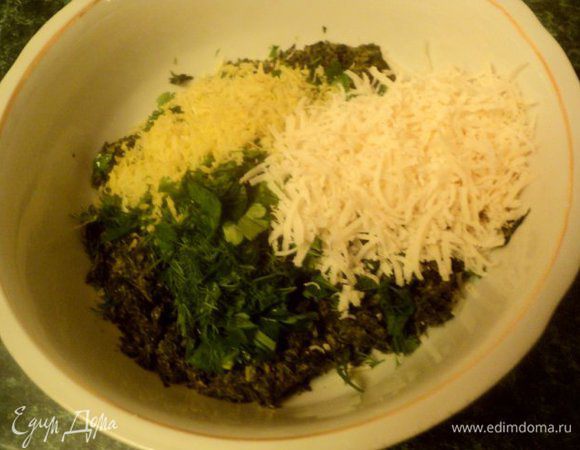 Добавить к шпинату мелко порезанную зелень, цедру с половины лимона, тертый пармезан и 1 яйцо, хорошо перемешать.