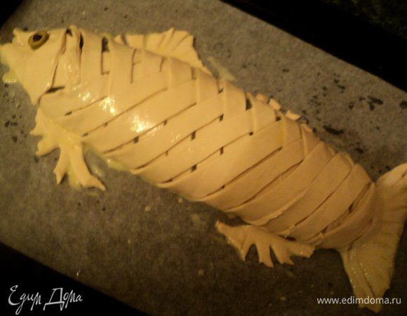 Завернуть лосось тестом в виде плетенки, сформировать головку и хвостик рыбы и плавники из остатков теста. Смазать сверху взбитым яйцом. Выпекать в духовке при температуре 180 градусов 1 час. Если будет слишком румяниться, накрыть фольгой.