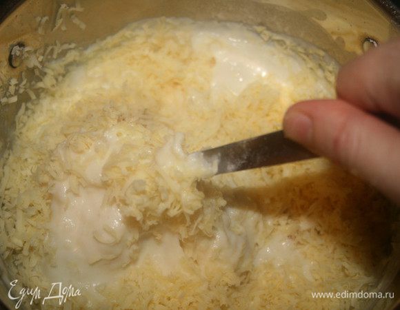 Убрать кастрюлю с огня, добавить соль, перец, мускатный орех и 200 г чеддра, хорошенько перемешать.