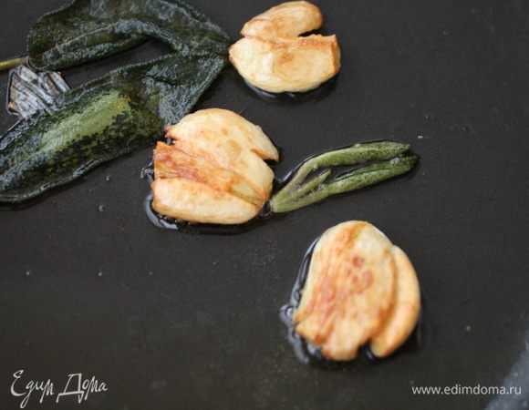 Разогреть оливковое масло, обжарить раздавленный чеснок и листики шалфея. 