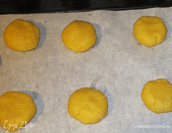 Взбить желтки венчиком и ввести в масляную крошку. Шоколад натереть на мелкой тёрке и ввести в тесто. Хорошо вымесить тесто, оно должно быть очень плотным. Сформировать шарики и выложить на противень с пергаментом.