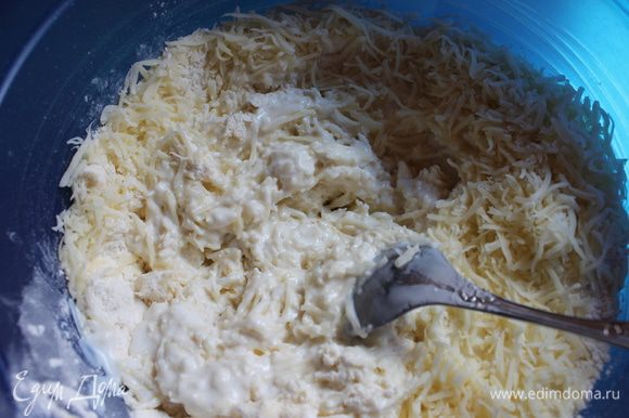 Добавляем тертый сыр и перемешиваем всё. Добавляем кефир или йогурт и замешиваем тесто. Оно будет липкое, можно добавить муки, но немного.