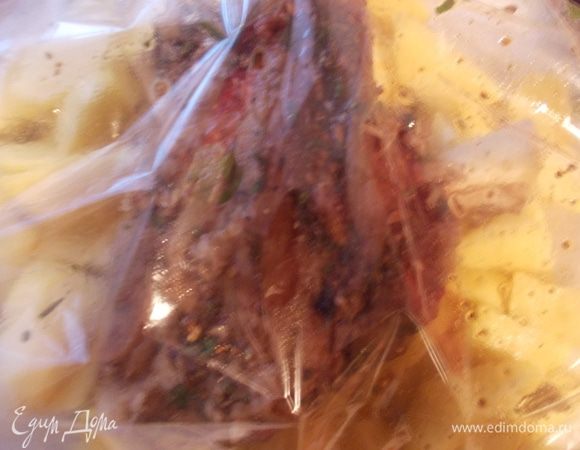 Затем взять пакет для запекания и сделать подушку из нарезанного картофеля. Сверху положить рульку и вылить соус в котором она мариновалась. Закрыть пакет и поставить запекаться при 220С на 40-45 минут, пока не приготовится картофель и не испечется рулька.