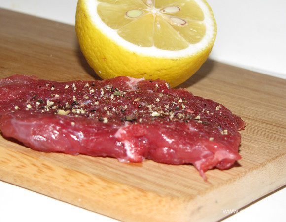 Мясо тонко нарежьте и слегка отбейте с двух сторон. Натрите отбивные солью и перцем, сбрызните лимонным соком.