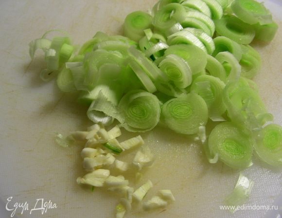 Лук-порей режем тонкими кружками, чеснок - мелко. Кладем овощи в сковороду, где жарилась курочка, при необходимости добавляем немного масла и обжариваем 4 минуты. 
