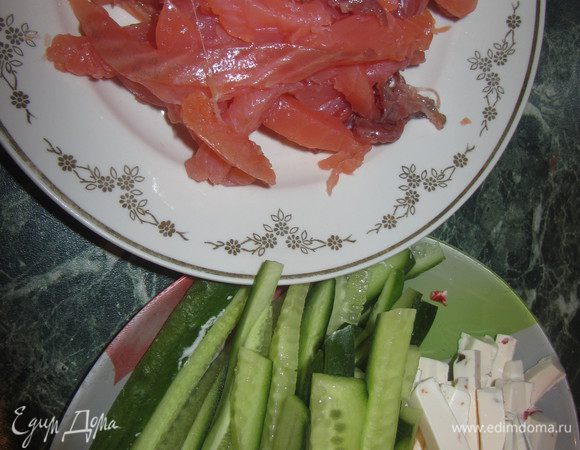 Пока рис варится, нарежьте тонкой соломкой рыбу, огурец и сыр.