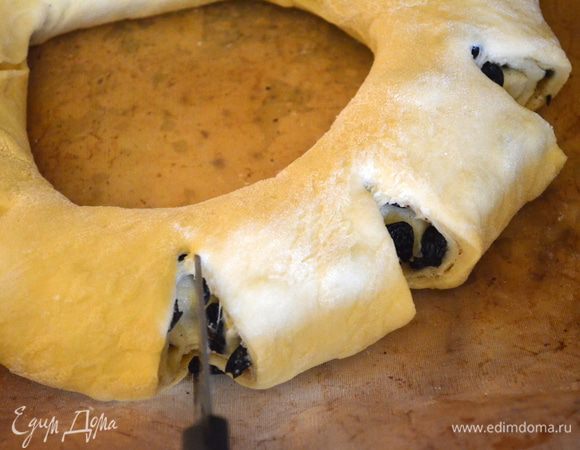 ножницами сделать надрезы по всему кругу, накрыть пищевой пленкой и оставить еще на 40 минут. Оно должно еще подняться. 