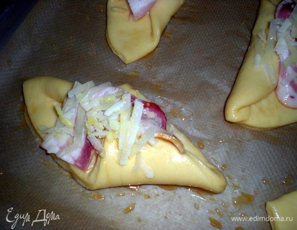 После расстойки смазать открытые участки теста яйцом.Посыпать сыром.Уменьшить температуру в духовке до 220 гр. и выпекать конверты в течении 15 минут до глубокого золотистого цвета.