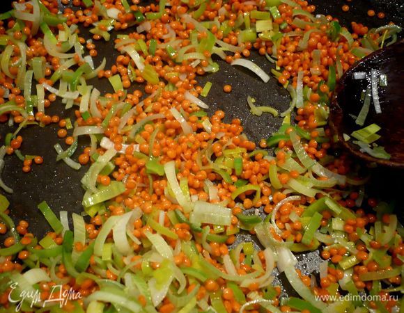 На сковороде разогреем пару ложек оливкового масла и слегка припустим в нем лук-порей, добавим чечевицу и обжарим около двух минут.  Добавим томатную пасту и снова обжарим в течение двух минут.