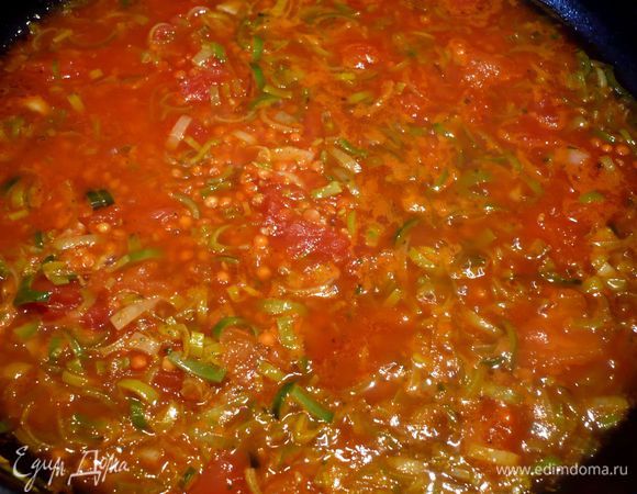 Добавим бульон и томаты. На медленном огне тушим около 15 минут, пока чечевица не будет готова.
