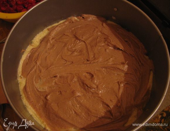 Половину теста выложим на противень. В оставшееся тесто добавим какао и 20 мл молока. Выложим его на светлое тесто и слегка перемешаем.