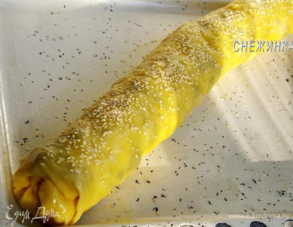 Противень смазываем сливочным маслом. Кладём на него рулет швом вниз. Смазываем оставшимся сливочным маслом. Сверху посыпаем семенем кунжута.