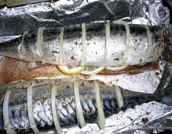 Затем надрежьте рыбу на порционные кусочки, не прорезая тушку полностью. В полученные надрезы вложите тонкие полукольца лука. В брюшко положите полукольца лимона.