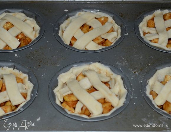 Разложим начинку, поделив ровно по порциям. Вырежем из теста также полоски для украшения наших мини-пирогов. Выложим их сверху начинки. Поставим в разогретую духовку выпекать 18 мин.