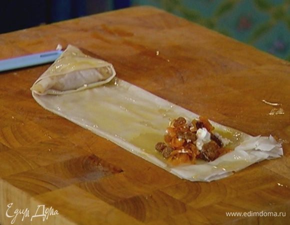 На один конец полоски выложить примерно 2 ст. ложки начинки из тыквы, и сложить край теста так, чтобы получился треугольник с начинкой внутри, верх промазать маслом и продолжить складывать тесто до середины полоски, каждый раз смазывая маслом верх пирожка. Затем сделать второй пирожок, начав со второго конца полоски. Когда пирожки «встретятся», разрезать полоску теста посередине. Так же сделать остальные пирожки.