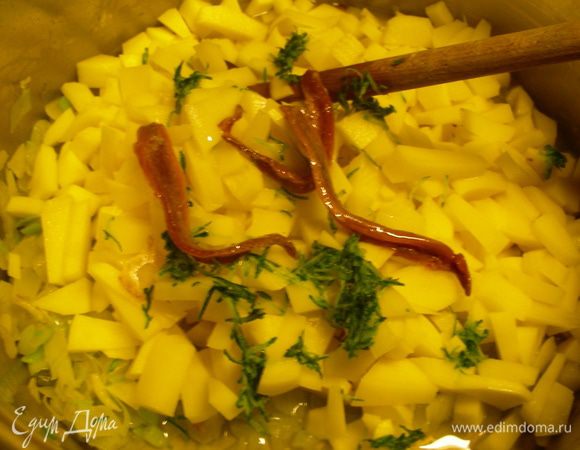 Выкладываем в кастрюлю картофель, тертую кожуру кабачка, анчоусы, заливаем вином. Увеличиваем огонь и выпариваем вино, больше, чем наполовину.
