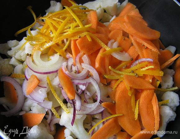 В сотейник с толстым дном выложить капусту, морковь, лук и цедру. Залить половиной соуса и варить 10-12 минут до готовности.