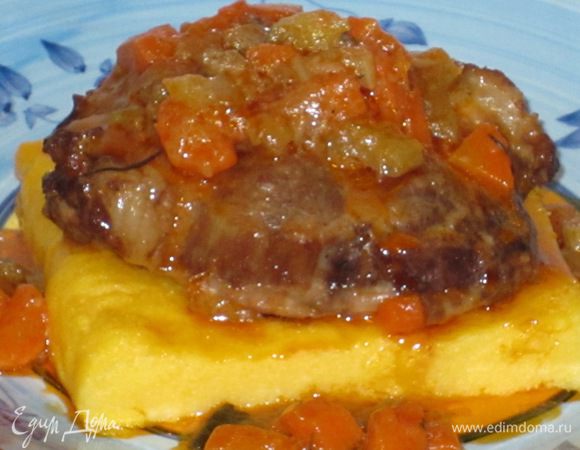 Мясо выложить на поленту и полить мясным соусом.