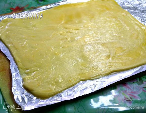 Подготовим рабочую поверхность. Отрезаем кусок фольги и смазываем его растительным маслом. На фольгу выкладываем расплавленный сыр, сверху накрываем пищевой плёнкой и раскатываем при помощи скалки в прямоугольник. Расплавленный сыр достаточно пластичный, поэтому никаких трудностей с раскаткой не возникает.