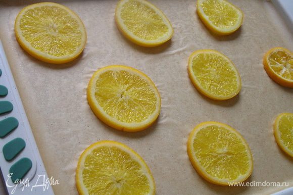 Подготовить противень (у меня 37х26х2см): застелить его бумагой для выпечки, смазать маслом, сверху выложить кружочки апельсинов.