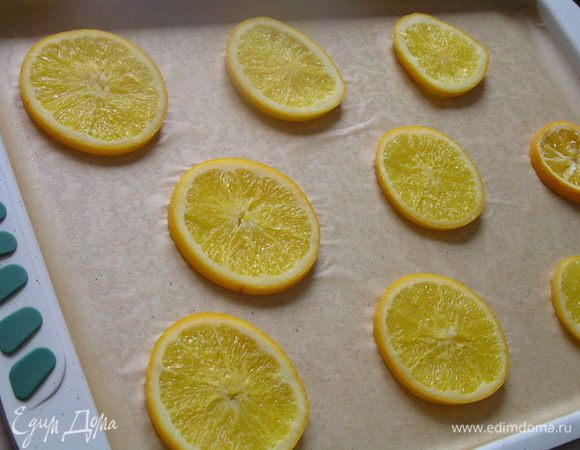 Подготовить противень (у меня 37х26х2см): застелить его бумагой для выпечки, смазать маслом, сверху выложить кружочки апельсинов.

