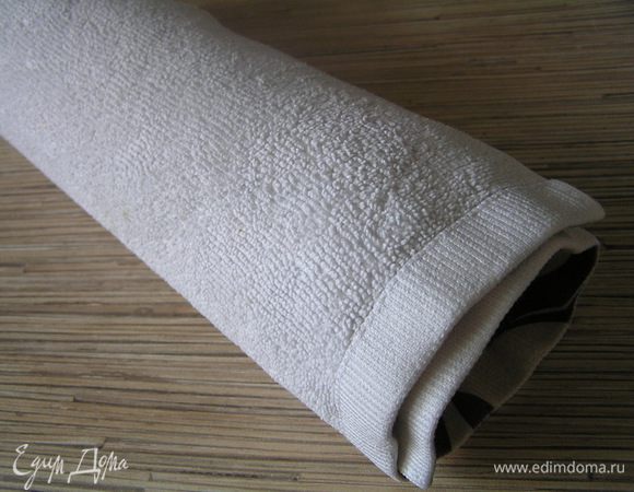 Перевернуть бисквит другой стороной (бумагой к полотенцу) на подготовленное полотенце и аккуратно свернуть в рулет. Оставить до полного остывания.
