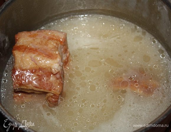 Сливаем лишний жир и добавляем горячий бульон или воду. Я использовала воду. Кипятим минут 10, потом накрываем крышкой и на медленном огне варим 30 минут. После этого грудинку убираем.