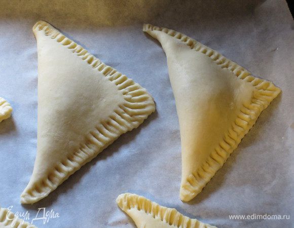 Края прижать и выложить на противень с пергаментом. Выпекать в разогретой до 170 °С духовке 25 минут.