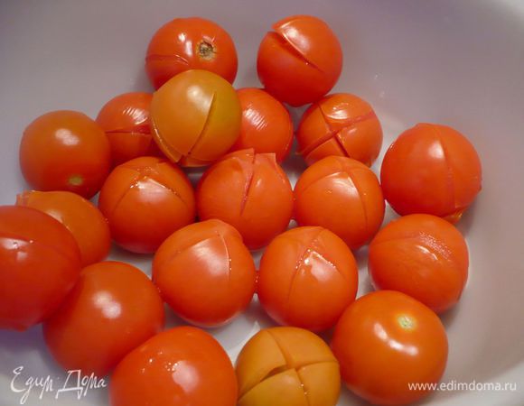 Помидоры надрезать крест накрест и опустить в кипяток на 30 секунд (дело в том, что у меня, увы, не оказалось крупных помидоров и я использовала помидоры черри (около 20 шт.), именно на это и ушло у меня больше всего времени), снять, начиная с надрезанного уголка, кожицу, вырезать острым ножом место прикрепления плодоножки.
