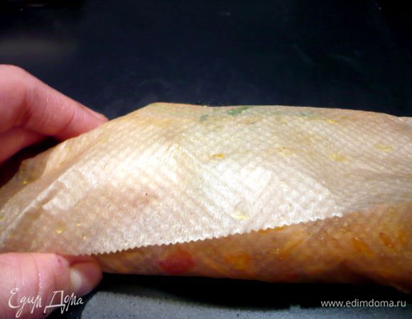 Заворачиваем наш конверт. Сначала закрываем рыбу передним краем бумаги, на нее кладем в нахлест задний край. Края слева и справа подворачиваем вниз, под конверт.