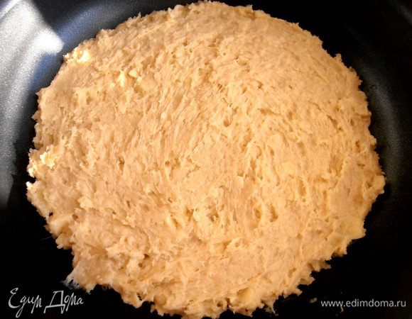 Тесто примерно разделим на три части и одну часть распределим ложкой по форме (у меня тефлоновая 22 см, которую ничем не смазывала).