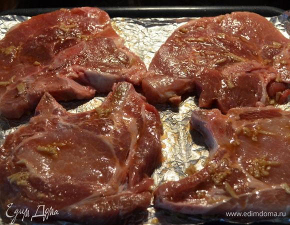 Смажем кисточкой каждую отбивную смесью одну сторону и выложим на противень не смазанной стороной.