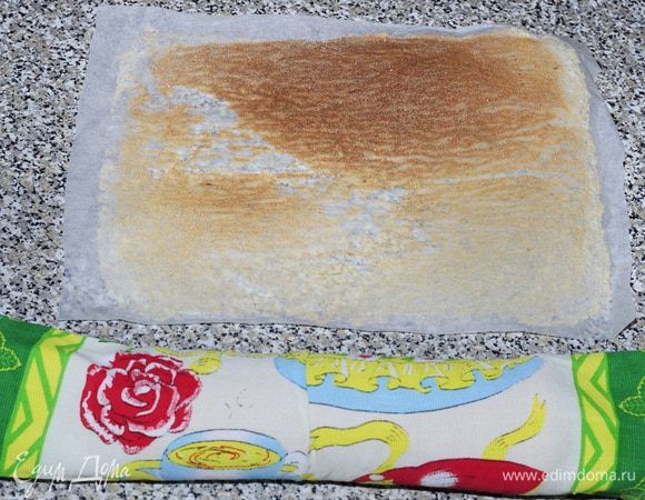 Полотенце присыпать сахаром, сверху положить бисквит, снять бумагу и свернуть рулетом, оставить до полного остывания