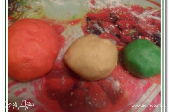 Полученное тесто раздеслить на 3 шарика: маленький (покрасить красителем в зеленый цвет), побольше (оставить белым) и самый большой (покрасить в красный цвет).