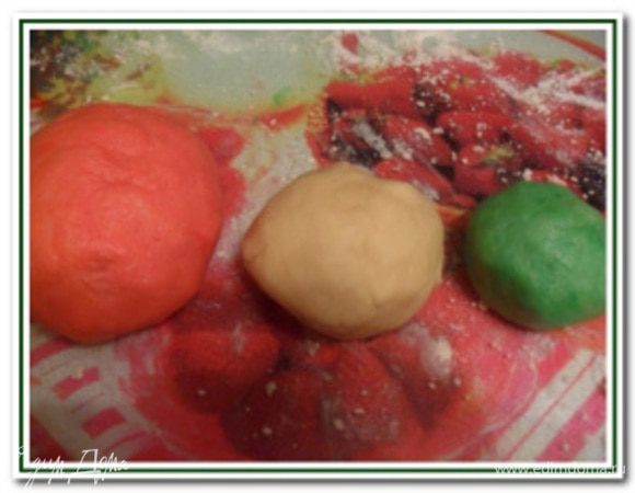 Полученное тесто раздеслить на 3 шарика: маленький (покрасить красителем в зеленый цвет), побольше (оставить белым) и самый большой (покрасить в красный цвет).