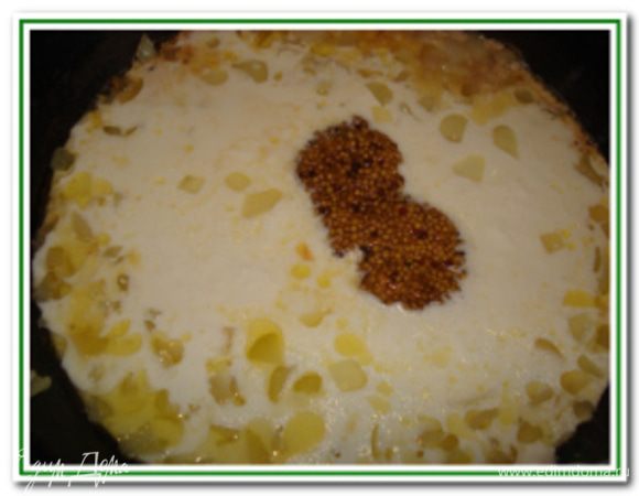 Лук нарежьте мелкими кубиками и обжарьте на сливочном масле до золотистого цвета. К обжаренному луку добавьте щепотку мускатного ореха и горчицу. Смешайте в отдельной чашке сметану с молоком и влейте к луку. Перемешайте, уменьшите огонь и готовьте до закипания.