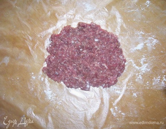 Небольшое количество фарша выложить на полиэтиленовый пакет, присыпанный мукой и разминая, формируем круг.